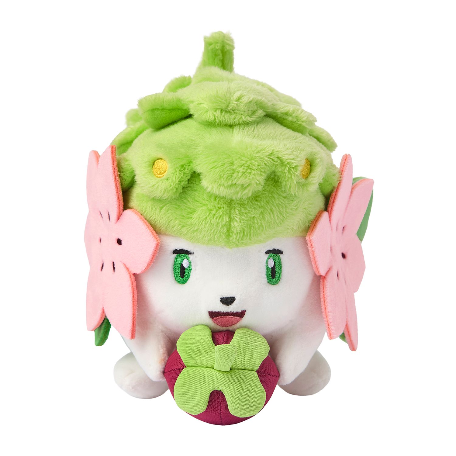 A Shaymin plush with a fluffy green back and two pink felt flowers, holding a round purple fruit with a green crown.