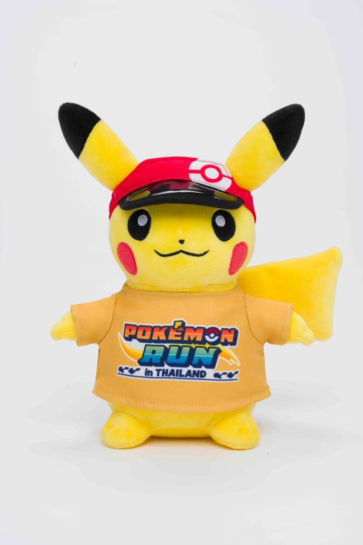 A Pikachu plush in a red cap and an orange Pokémon RUN in Thailand T-shirt.