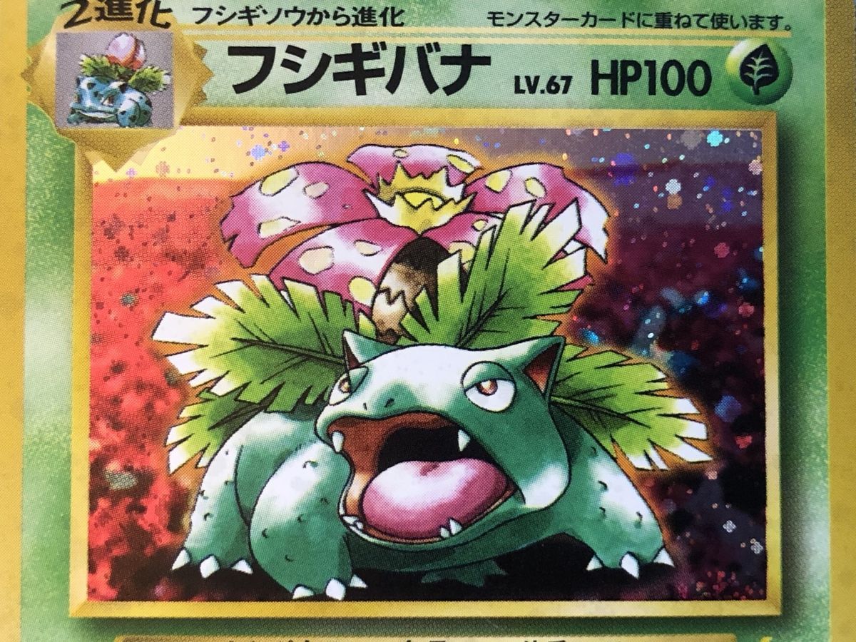 Macro photograph of a Japanese Base Set Venusaur artwork window: coarse pixelated orbs with squared-off edges.