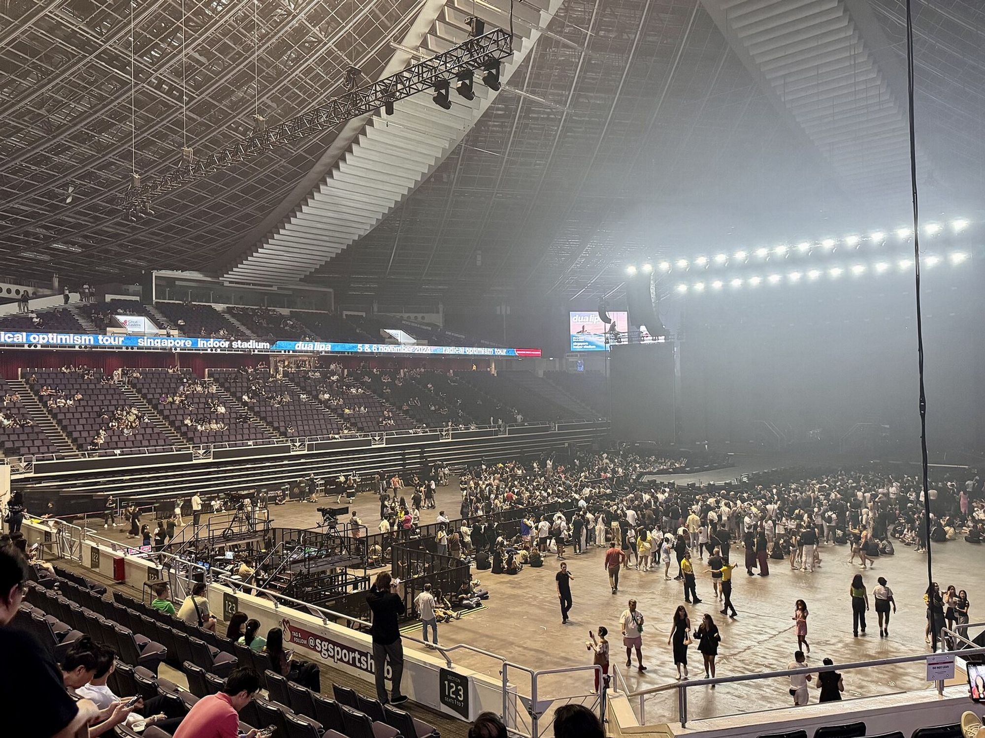 The interior of the Singapore Indoor Stadium set up for a concert, with a standing floor, tiered seating and a lit stage.