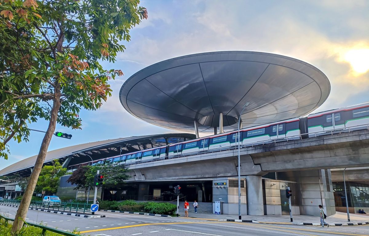 The Expo MRT station in Singapore, with its large disc roof and a train on the viaduct.