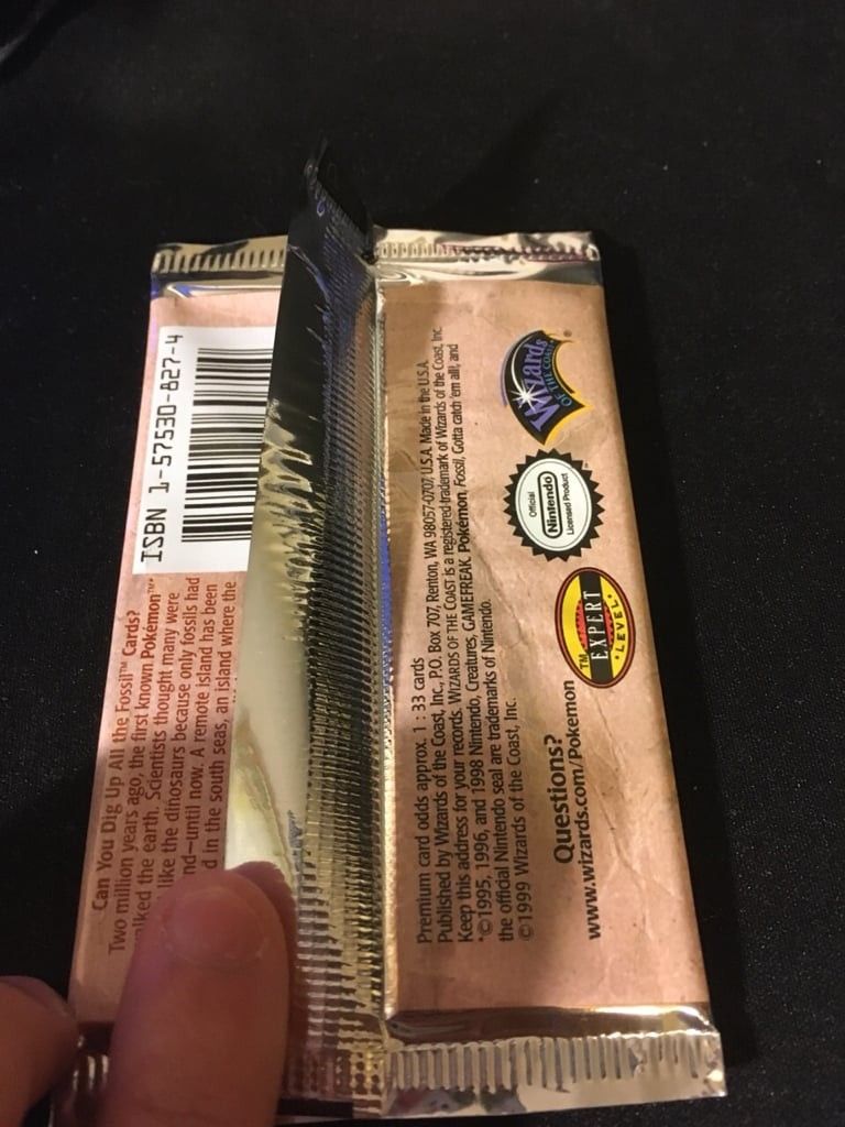 A Fossil booster pack whose back flap stands up, straight out of a sealed box.