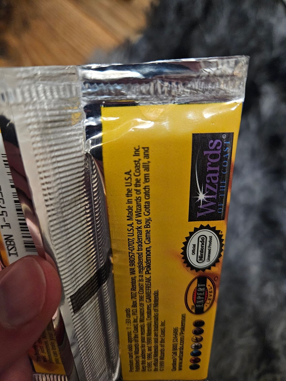 A questioned Base Set pack beside a normal one: its crimp is splayed and glossy.