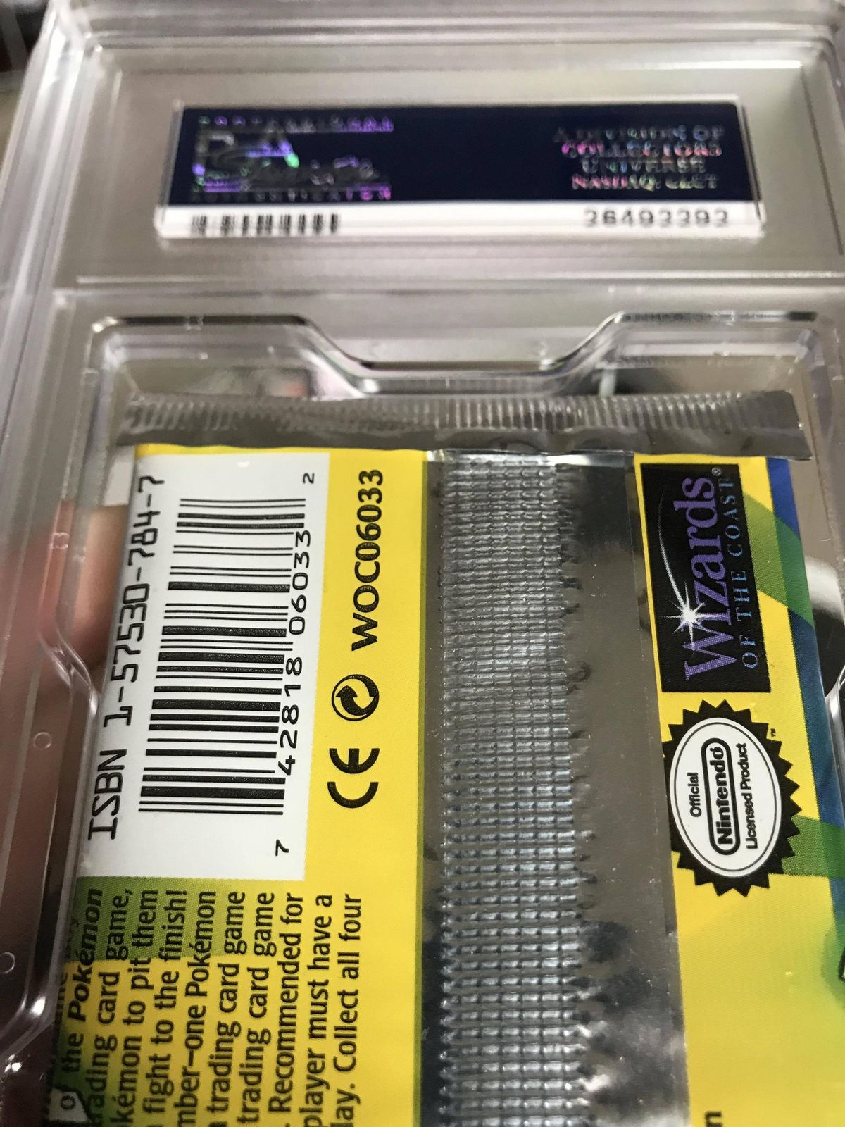 The bottom crimp of a 1999 Base Set 1st Edition pack inside a PSA 9 case, with adhesive smeared along the crimp.