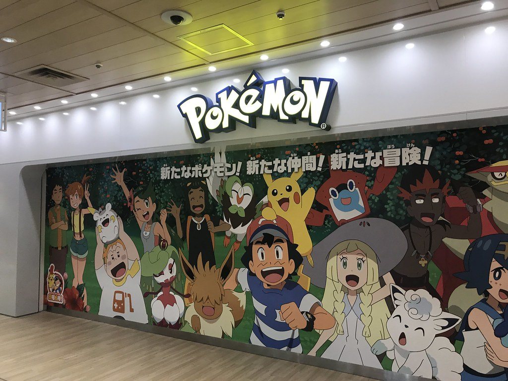 The wall outside Pokémon Center MEGA TOKYO, a POKÉMON wordmark above a mural of anime characters.